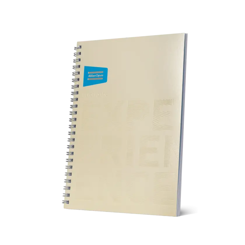 beige notebook with atlas copco logo and brand promise in beige embossed text
